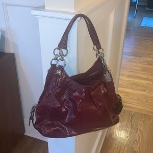 Cranberry patent leather Coach shoulder bag.